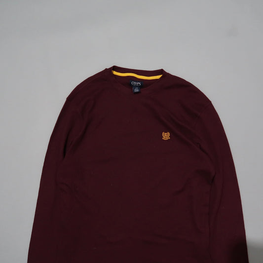 Maroon long-sleeve shirt with small logo on chest, on gray background.