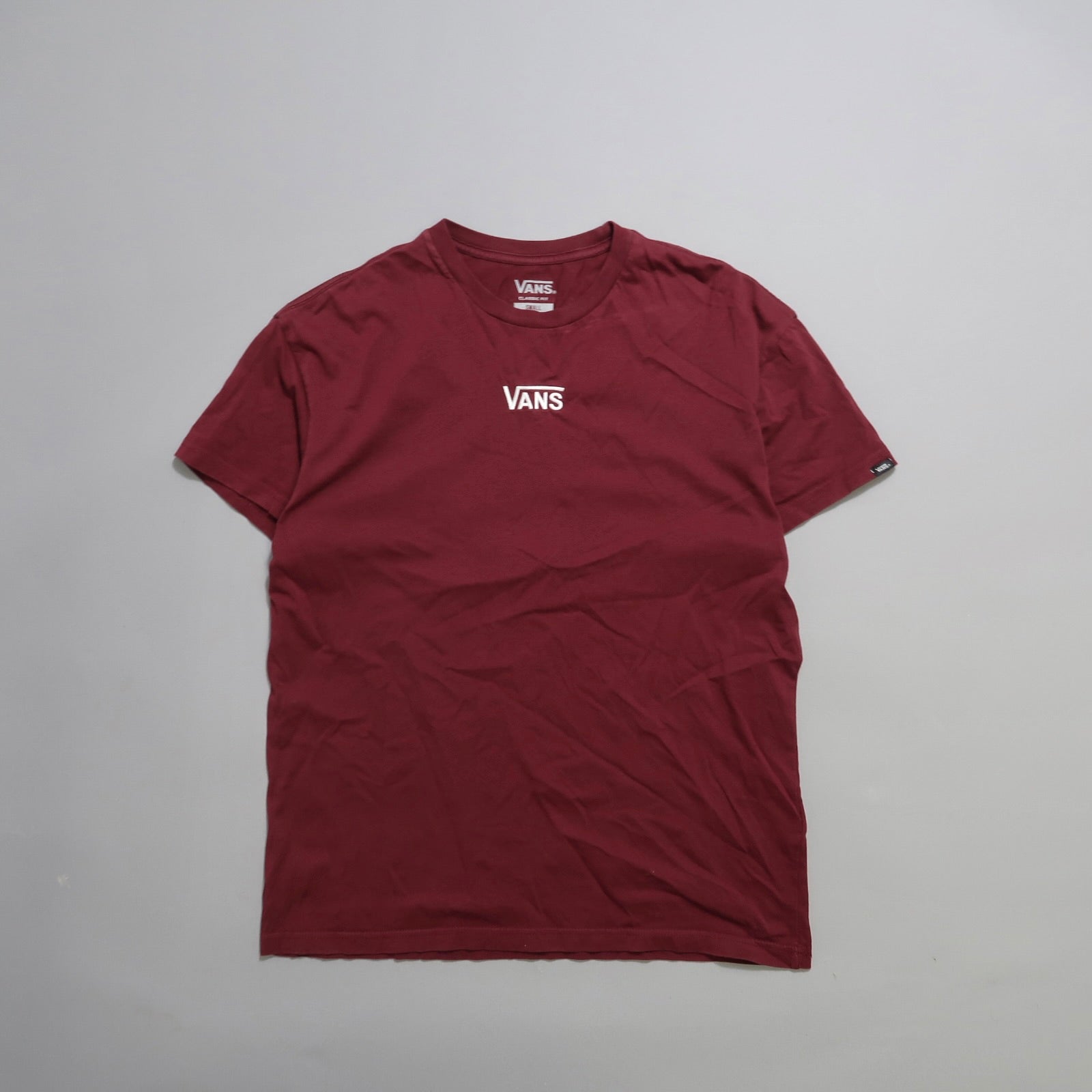 Maroon Vans T-shirt laid flat on a plain background.