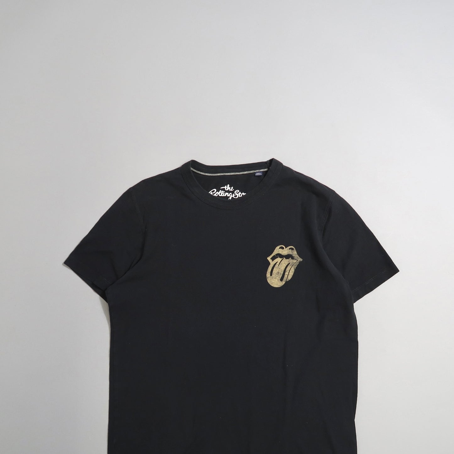Black t-shirt with tongue and lips logo on the upper left.