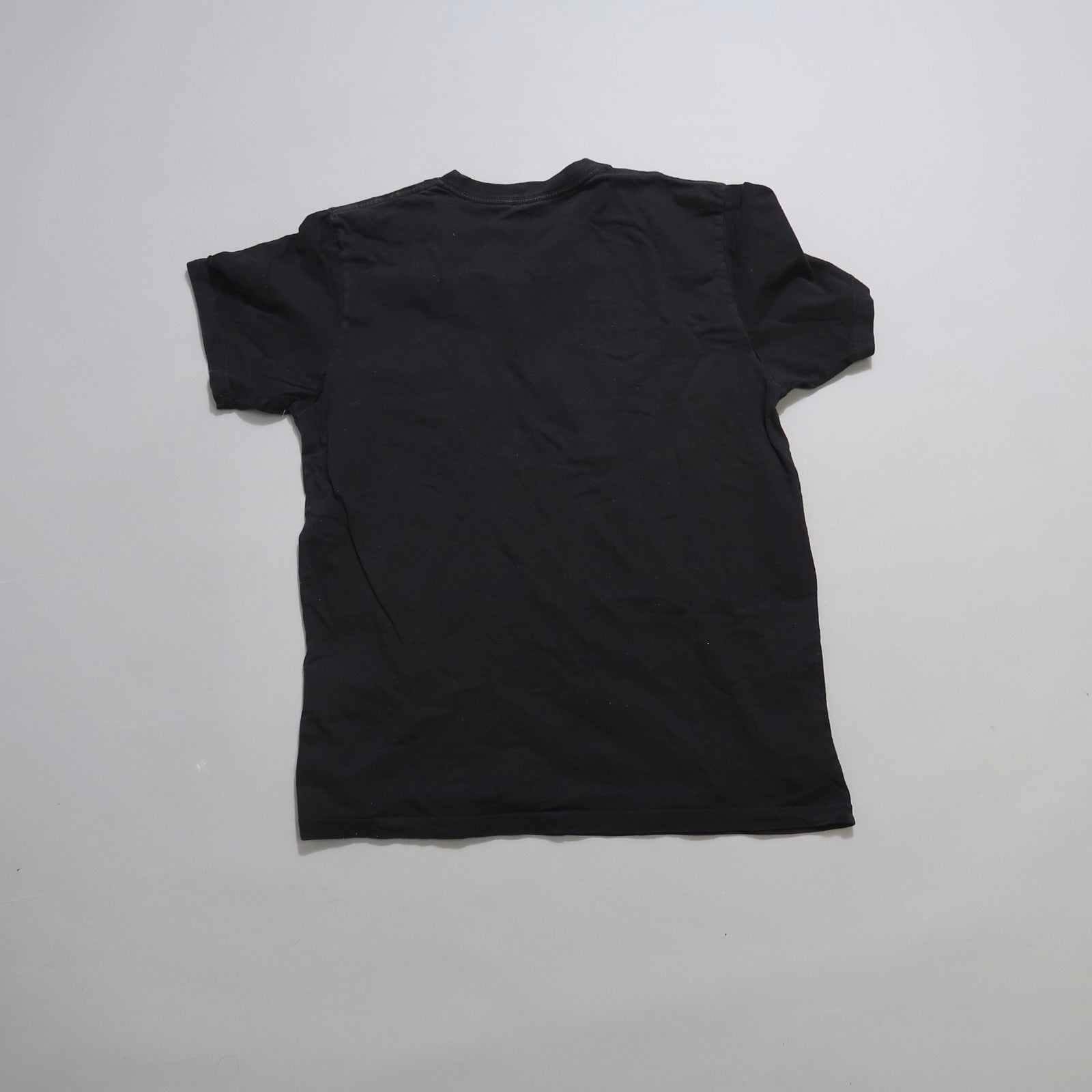 Black T-shirt facing backward on a plain white background.