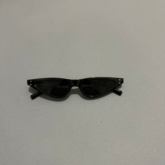 Black cat-eye sunglasses on a gray surface.