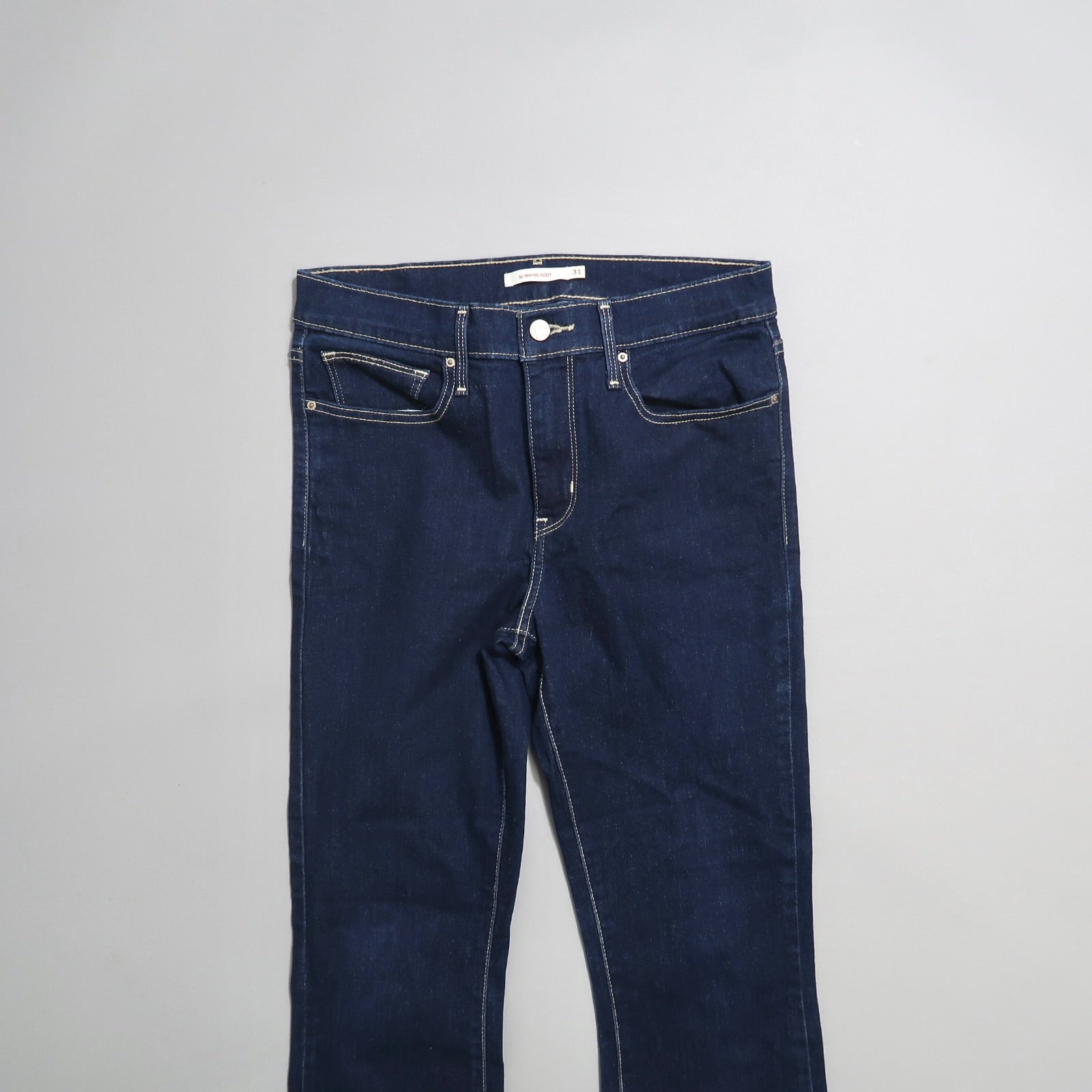 Dark blue jeans on a gray background.