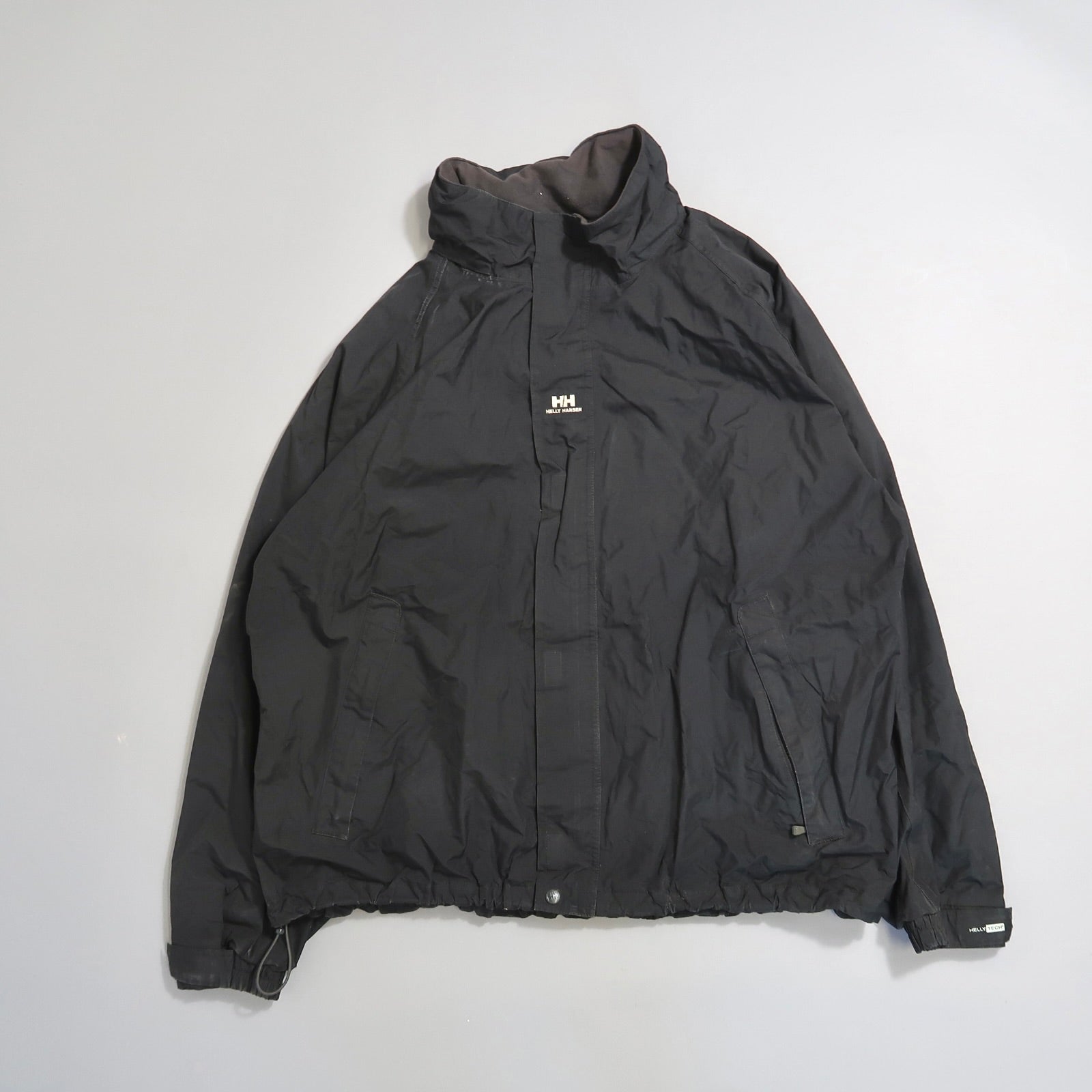 Black jacket with a high collar and small logo on the front.