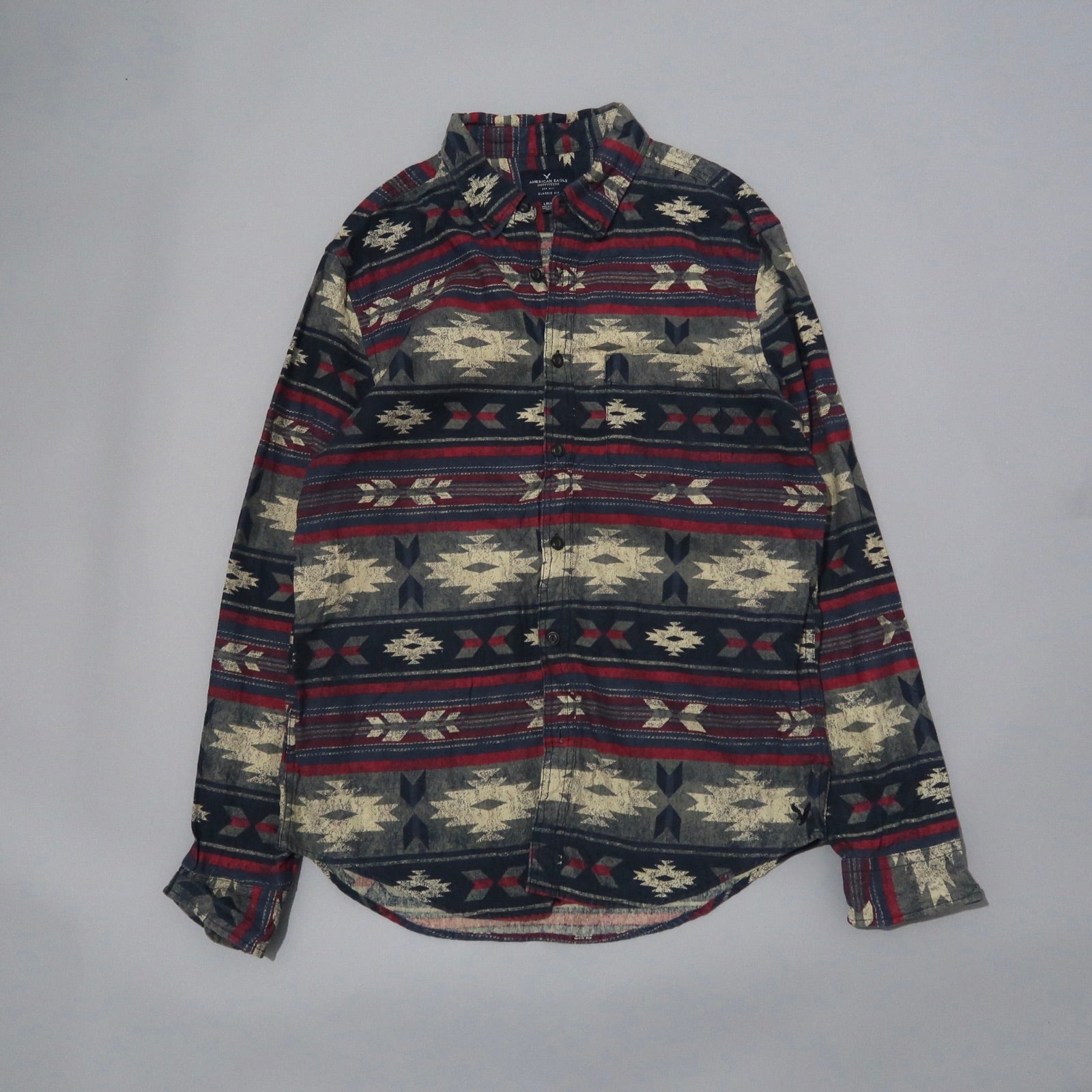 Patterned long-sleeve button-up shirt with red, navy, and beige design.