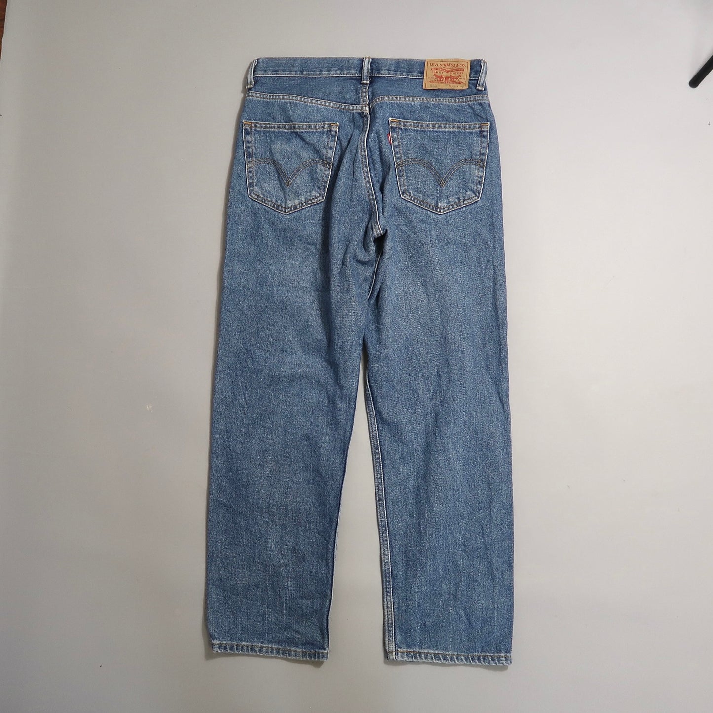 Back view of blue jeans on a plain background.
