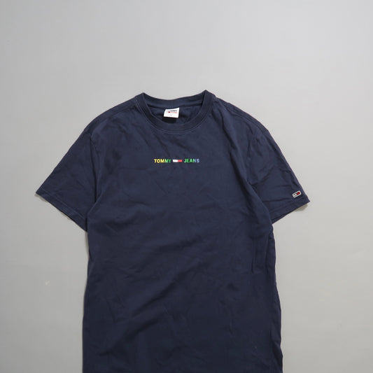 Navy blue Tommy Jeans T-shirt on a gray background.