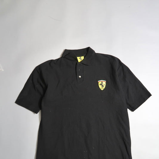 Black polo shirt with yellow logo on the chest.
