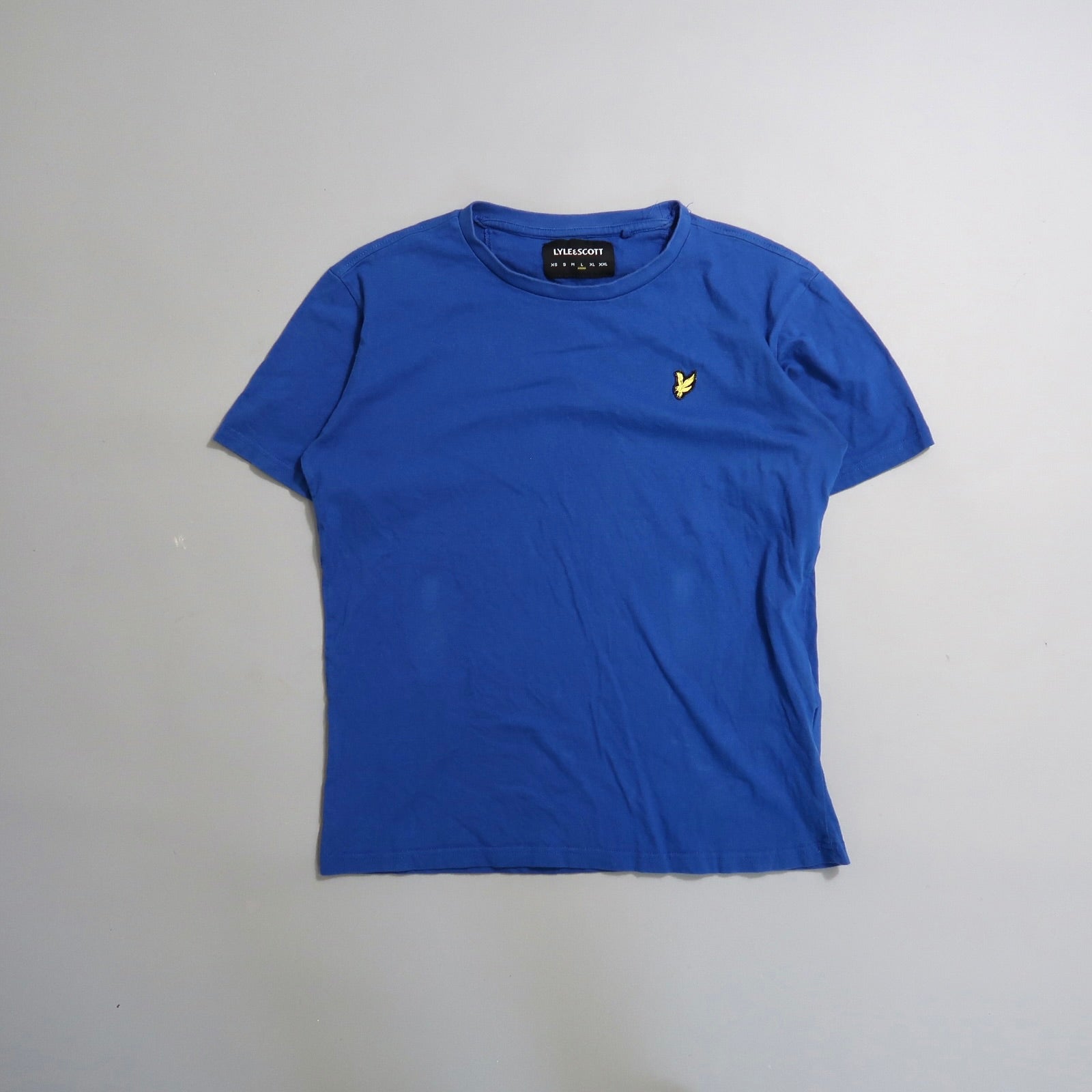 Blue T-shirt with a small yellow bird logo on the chest.