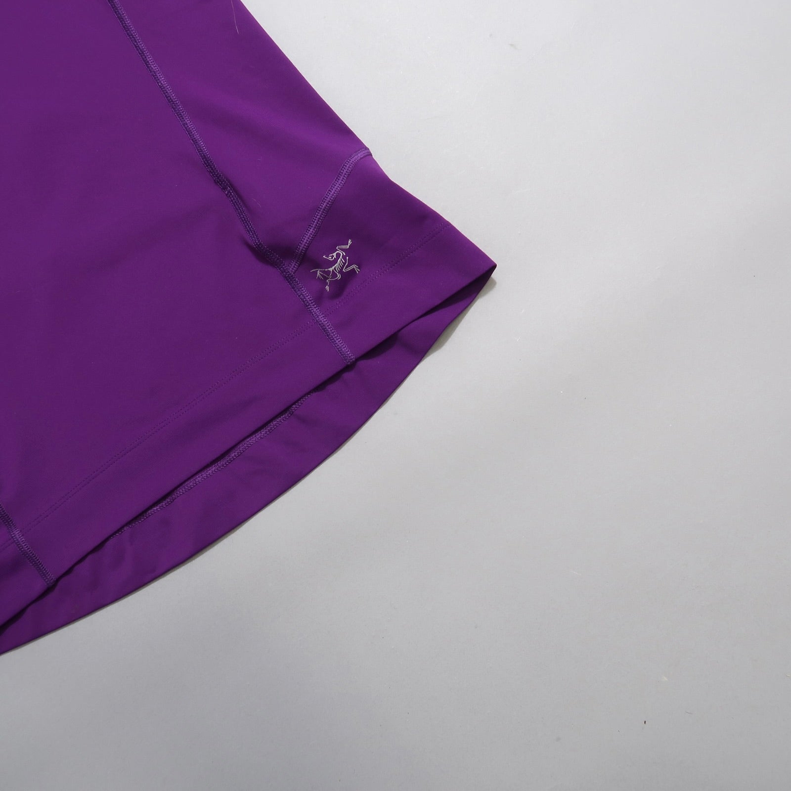 Purple garment corner with logo, set on a light background.
