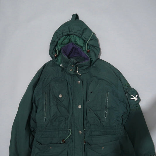 Green hooded parka with multiple pockets and embroidered patch.