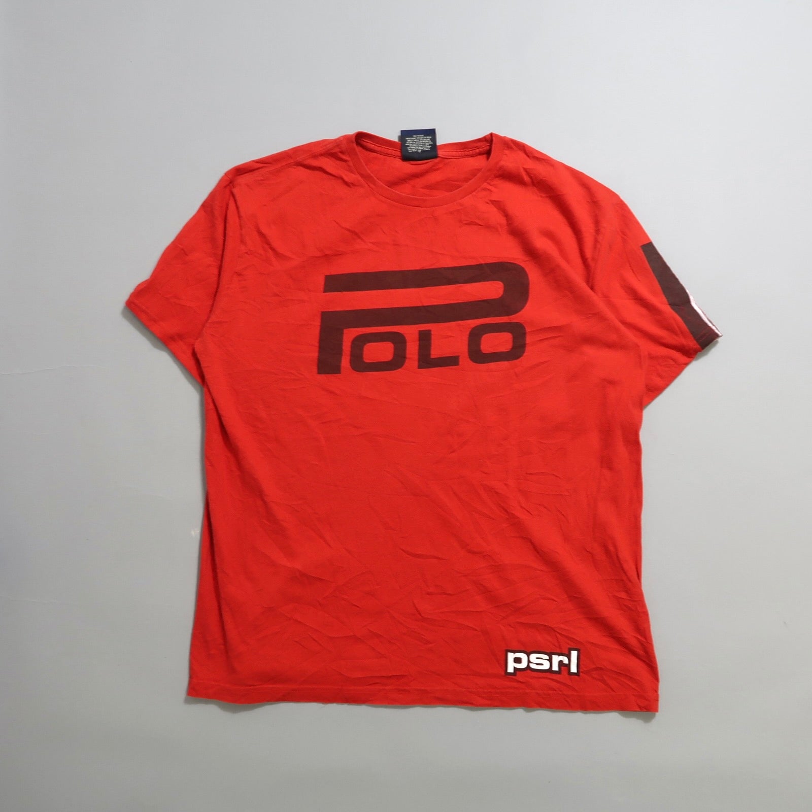 Red T-shirt with bold “Polo” logo and “psrl” text on sleeve.