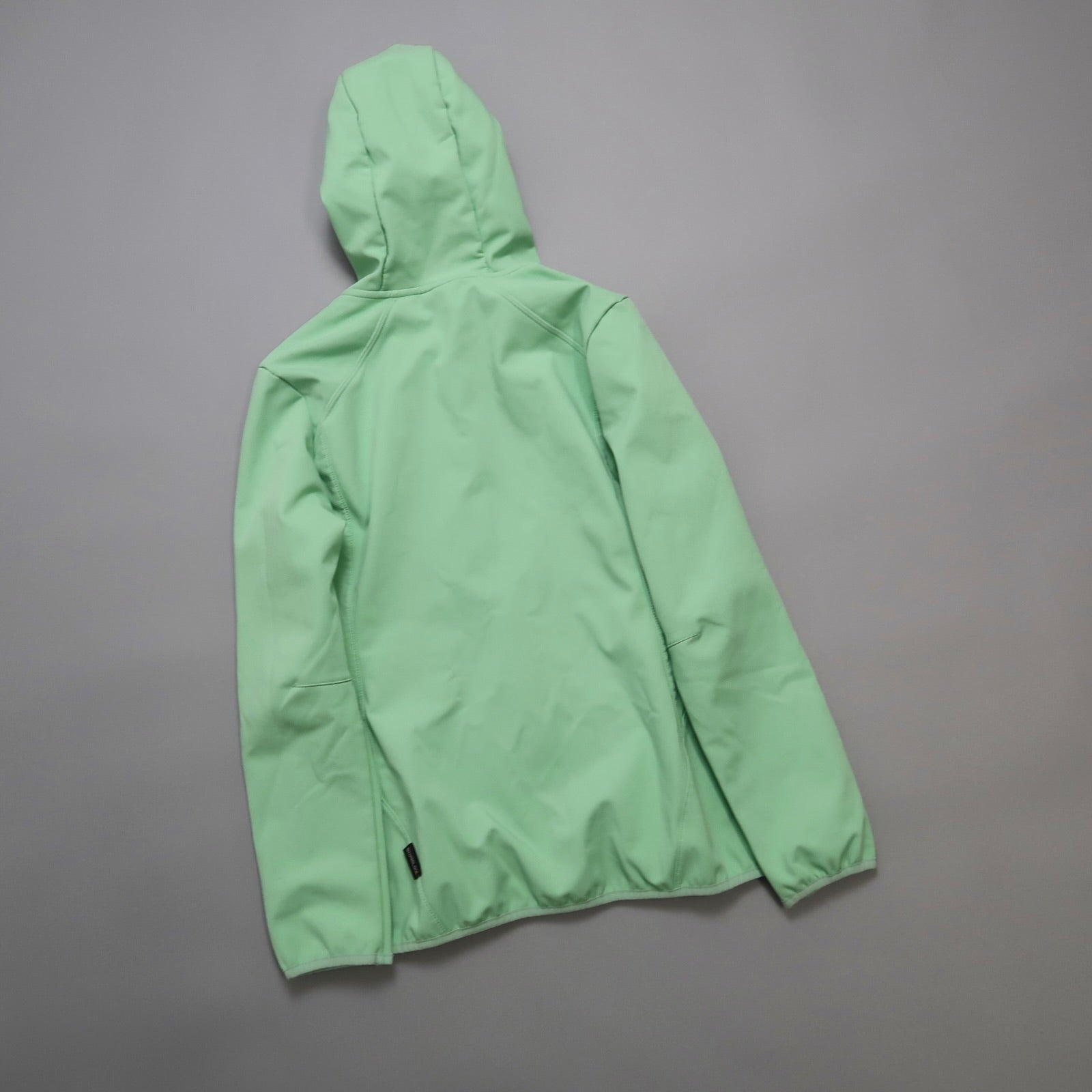 Mint green hooded jacket on a grey background.