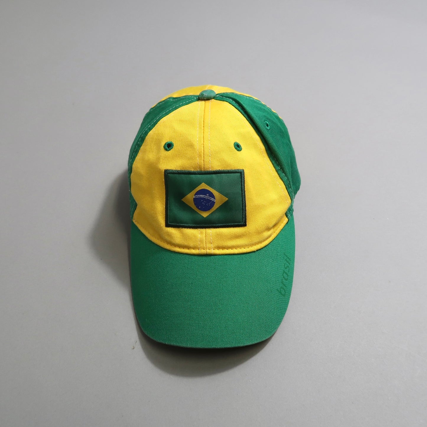Green and yellow cap with Brazil flag emblem.