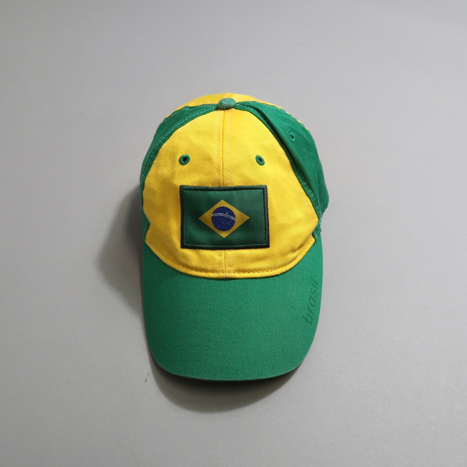 Green and yellow cap with Brazil flag emblem.