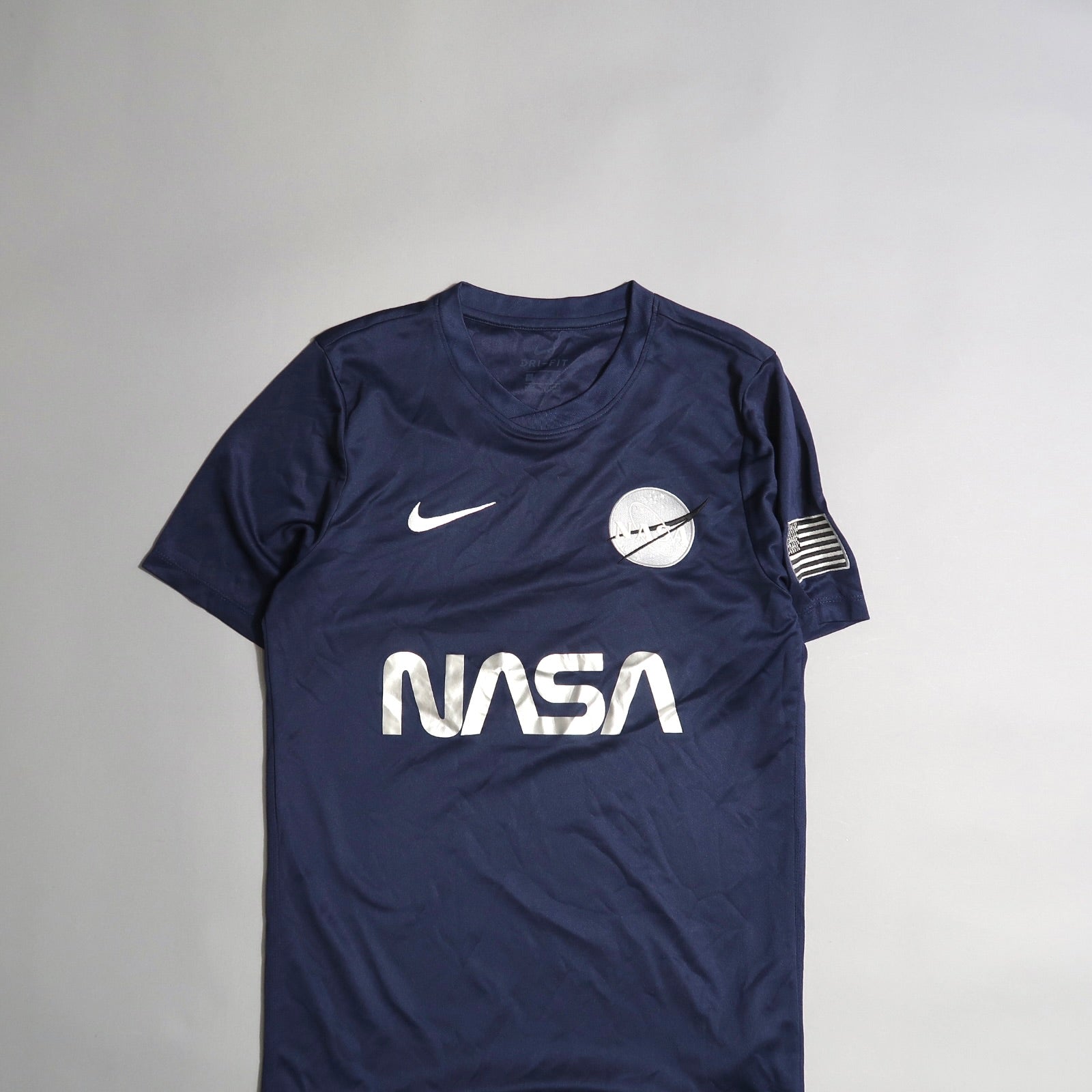 Navy blue NASA shirt with Nike logo and space-themed patches.