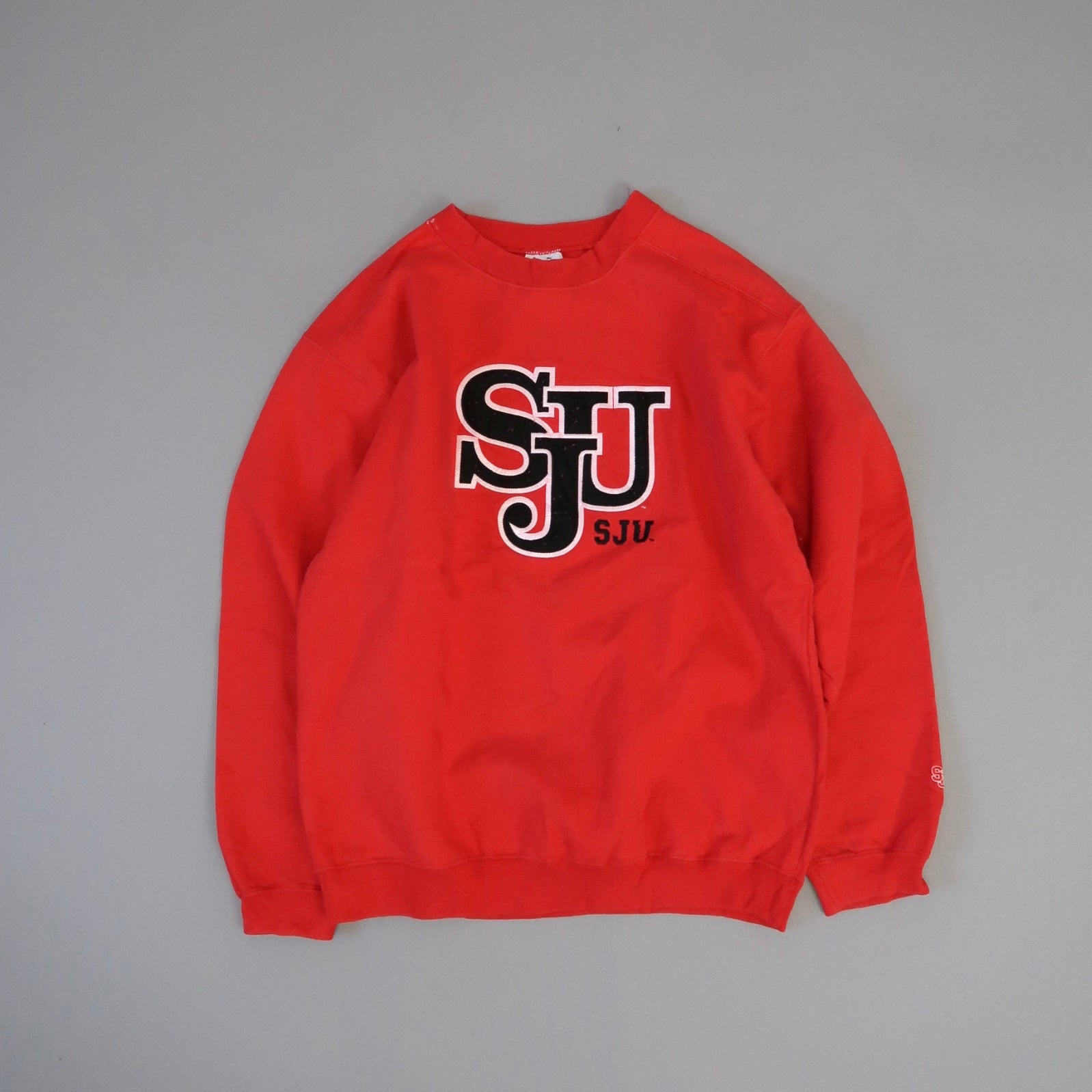 Red sweatshirt with nullSJUnull logo on the front.