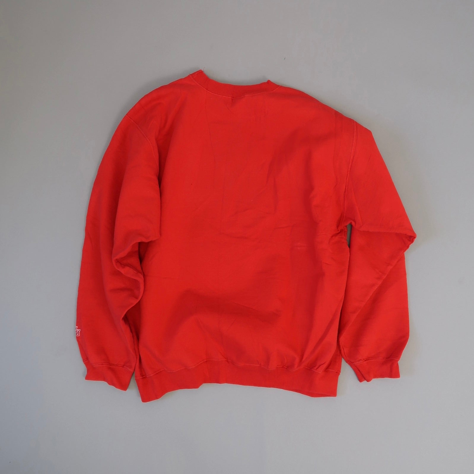 Red crewneck sweatshirt laid flat on a light gray background.